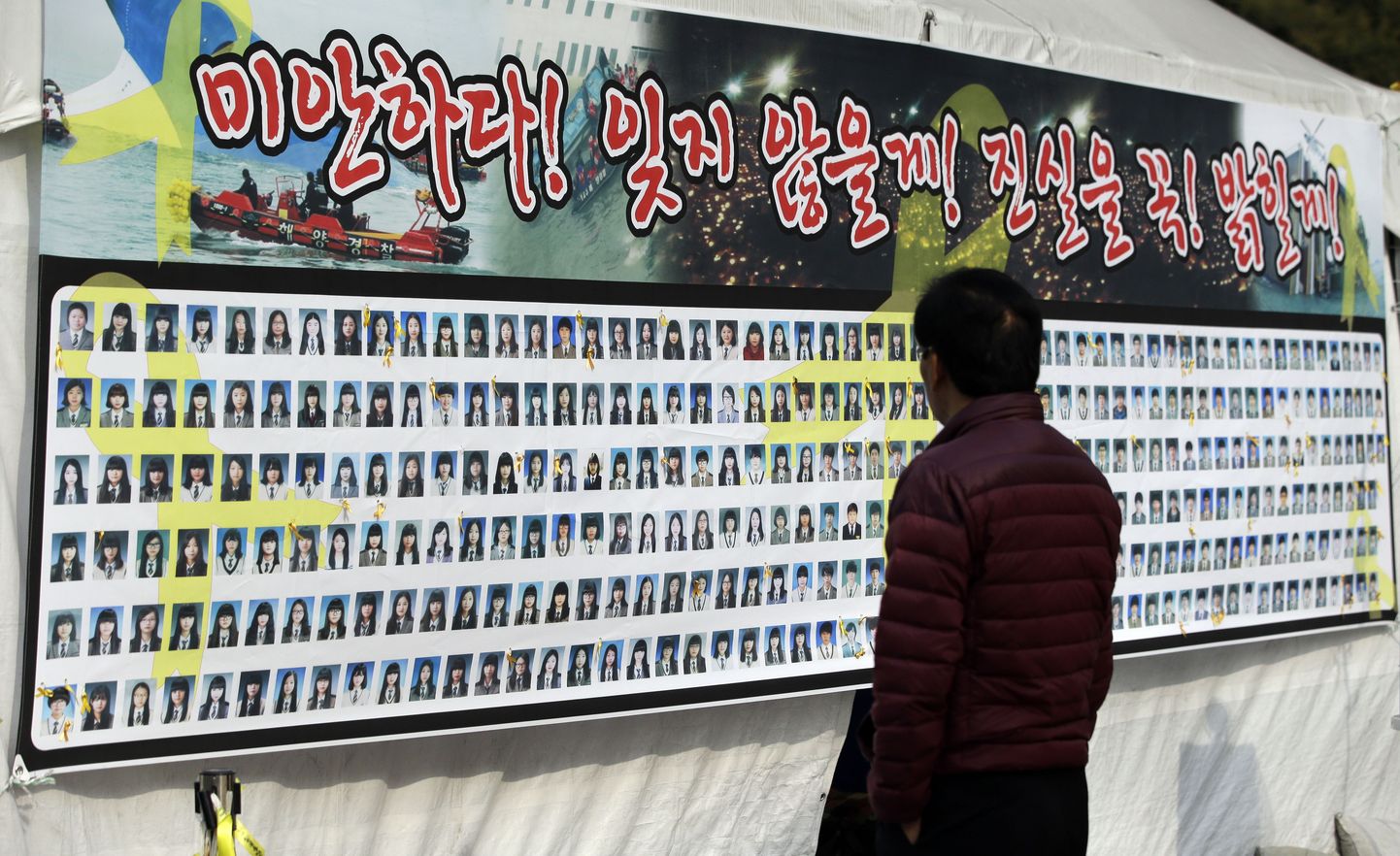 Mees vaatab reisiparvlaeva Sewol katastroofis hukkunud inimeste fotosid.