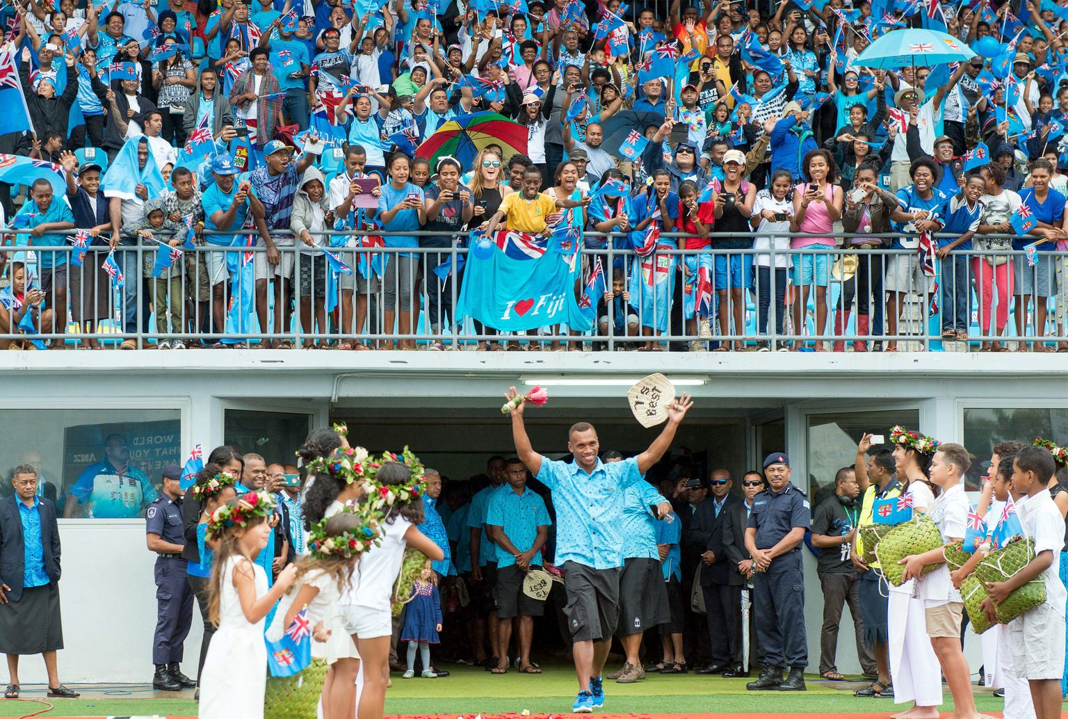 Fiji ragbimeeskonna mängijad kodumaal fänniarmee ees.
