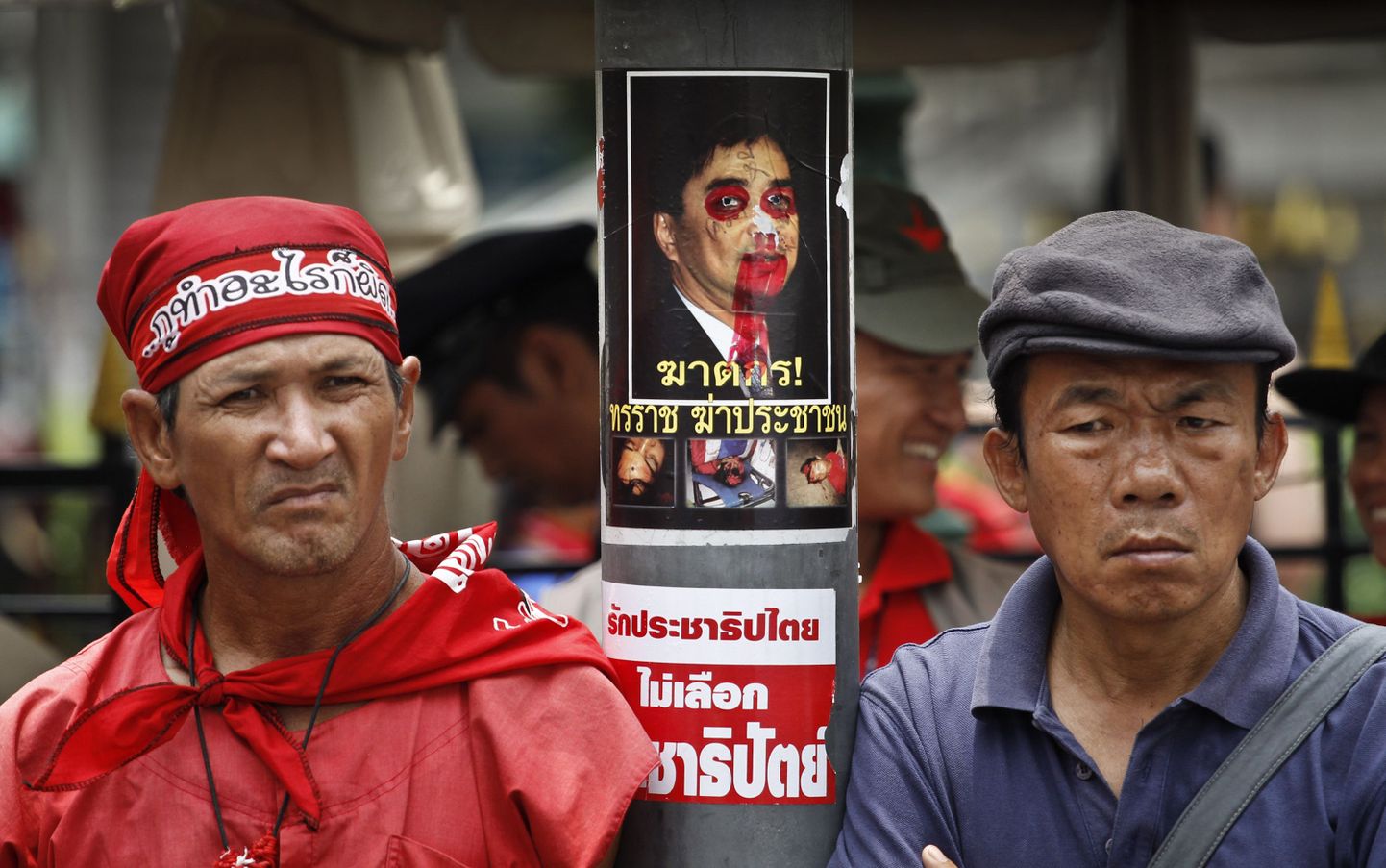 Tai valitsusvastased meeleavaldajad peaministrit solvava portree kõrval seismas.