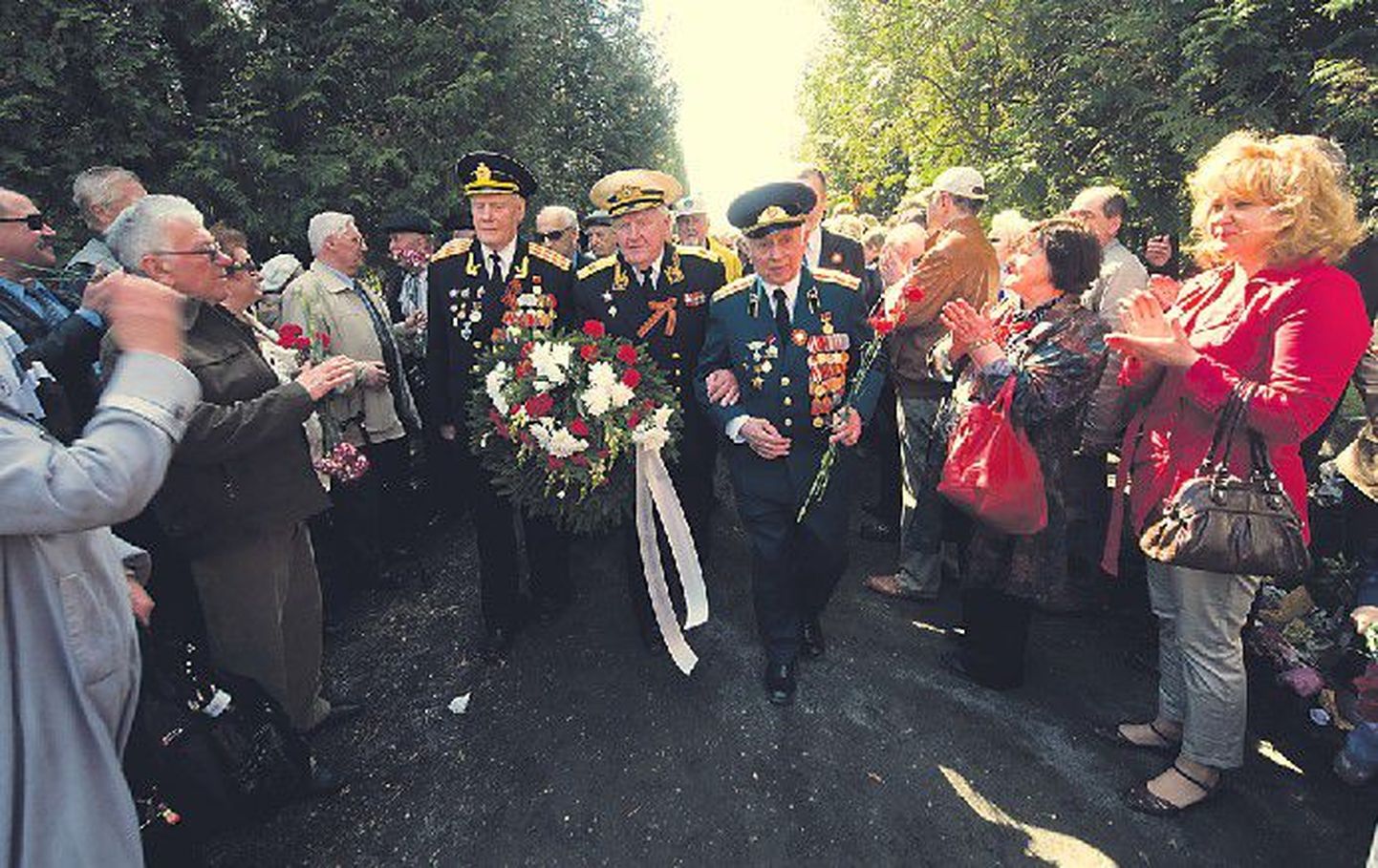 Люди встречали ветеранов, направлявшихся к Бронзовому солдату на Военном кладбище, аплодисментами и криками:   «Спасибо!».