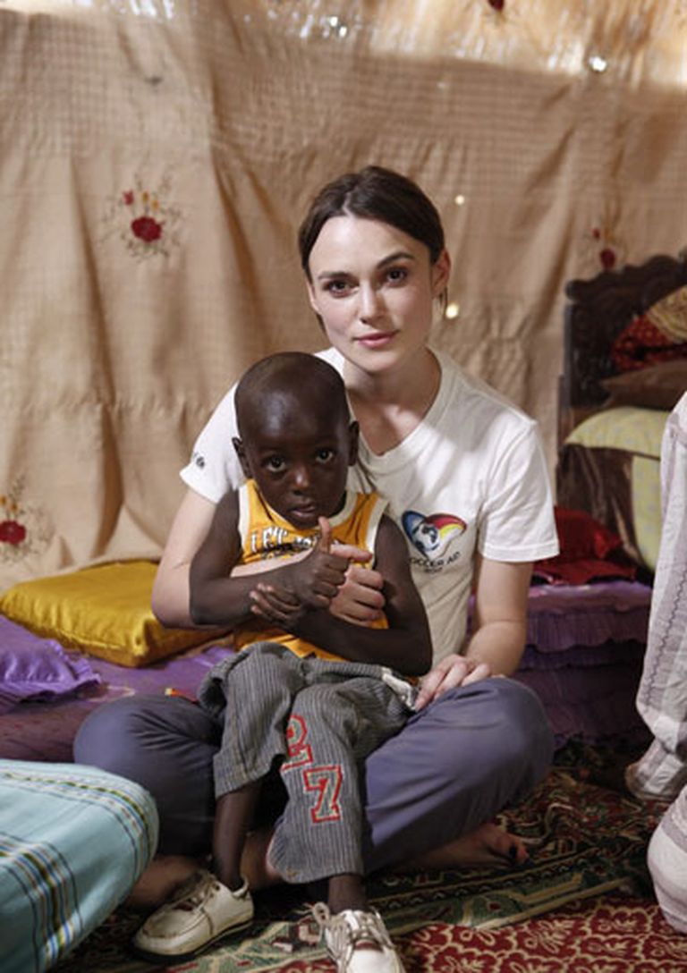 Aktrise Keira Naitlija ar vienu no slimajiem Āfrikas bērniem 