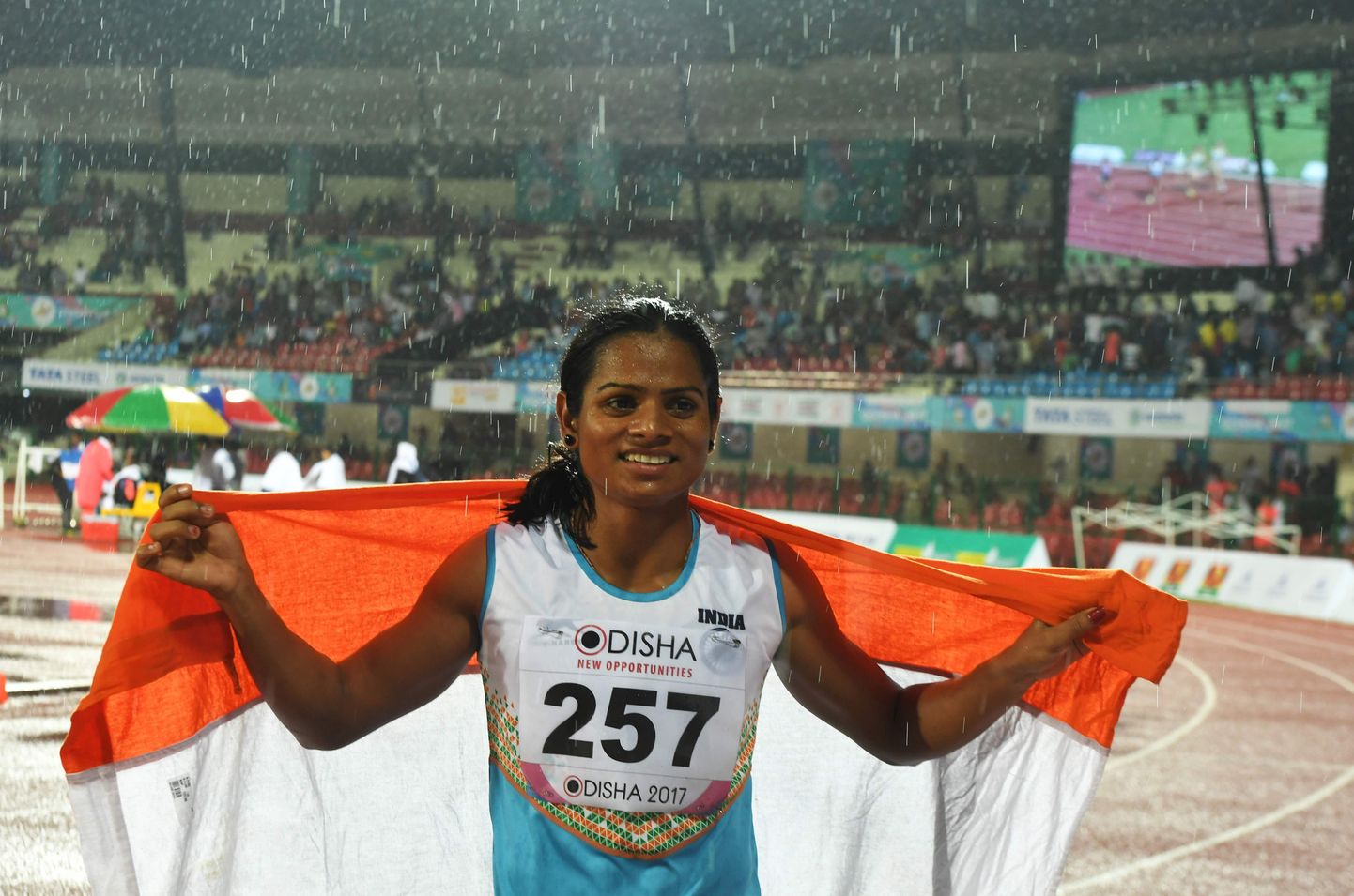 India's Dutee Chand celebrates after placing third in the women's 100m event during the second day of the 22nd Asian Athletics Championships at Kalinga Stadium in Bhubaneswar on July 7, 2017.

 / AFP PHOTO / Dibyangshu SARKAR