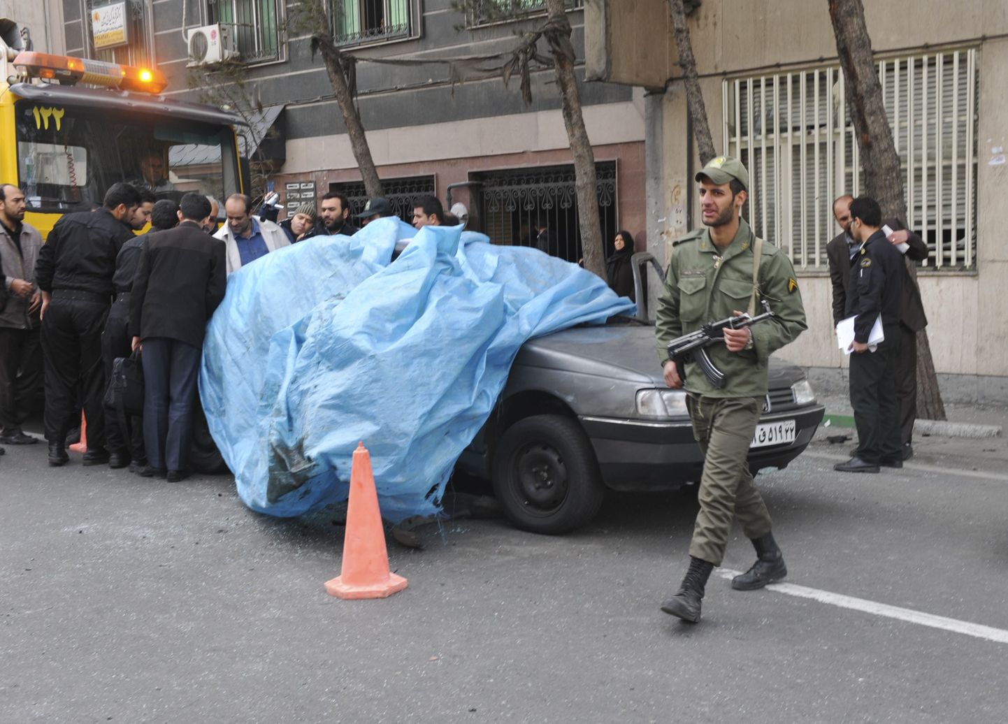 Iraani politseinikud ja eksperdid auto juures Põhja-Teheranis, mis lendas täna magnetpommi tõttu õhku.