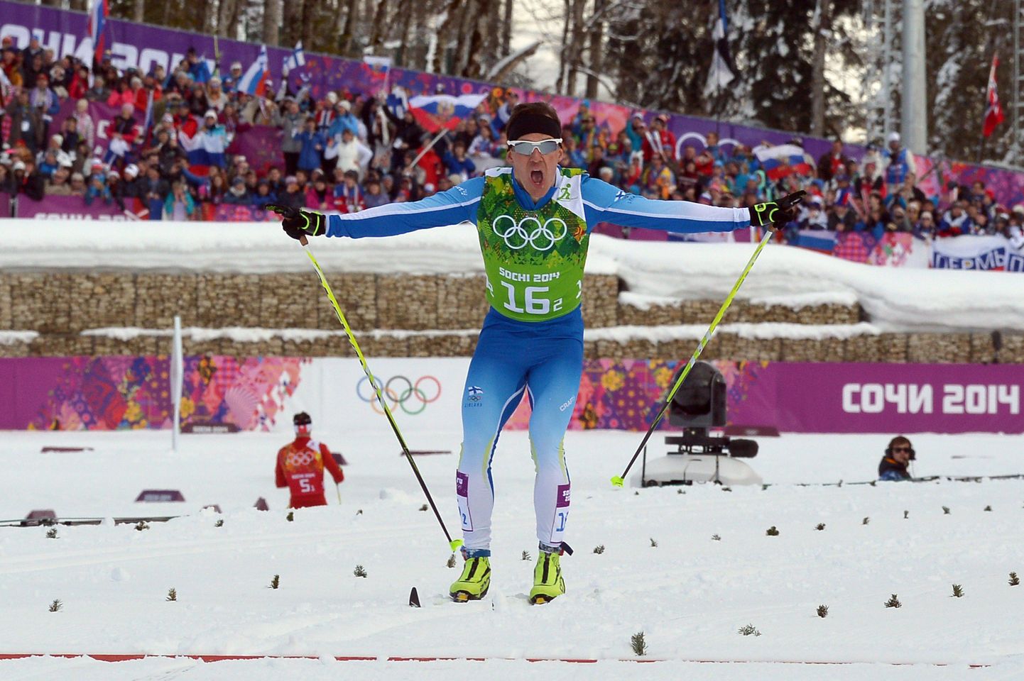 Финский лыжник финиширует в командном спринте.