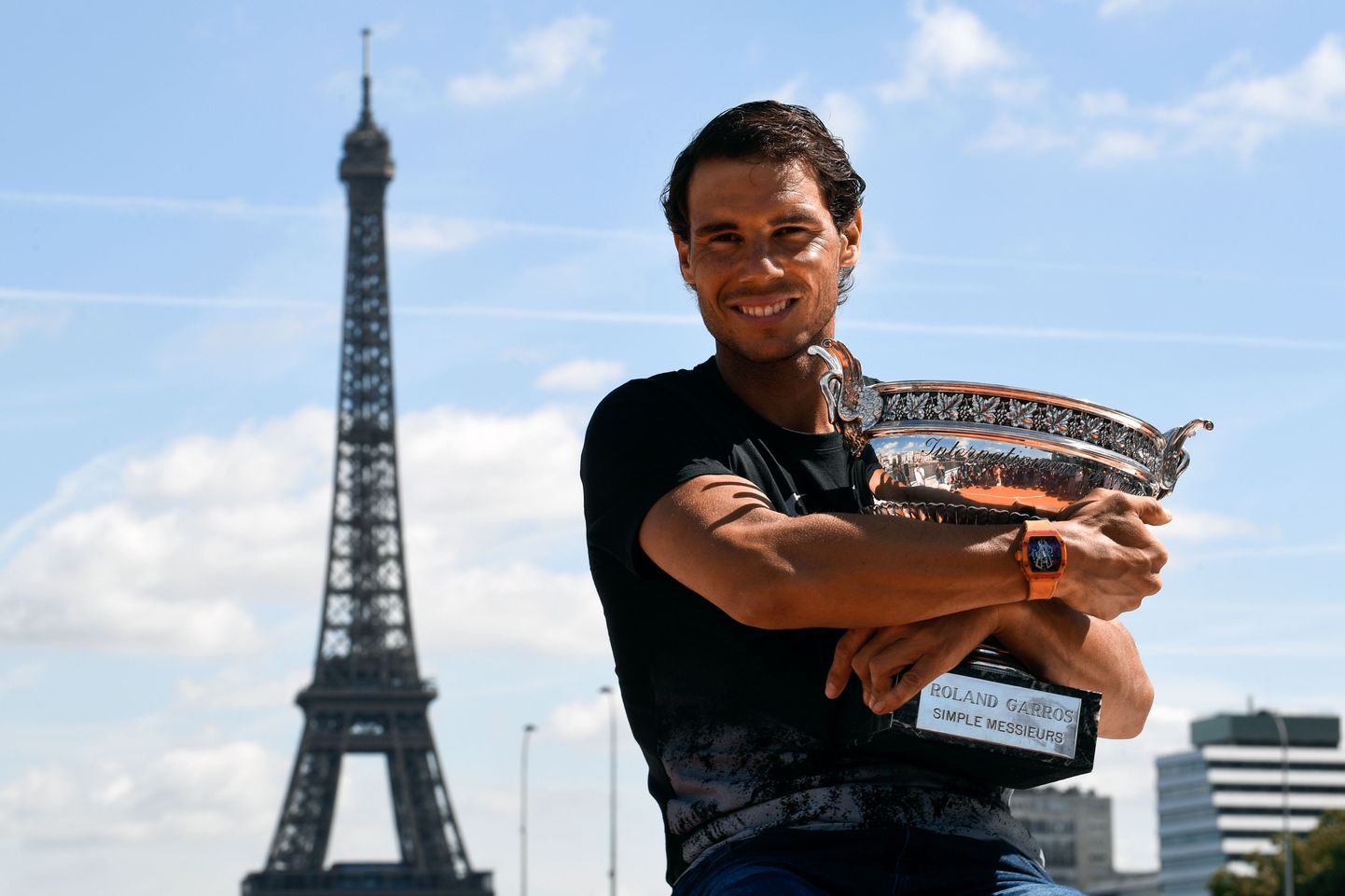 TOPSHOT - Spain's Rafael Nadal poses with the winner's trophy a day after he won the men's Roland Garros 2017 French Open on June 12, 2017 in Paris, with the Eiffel Tower in Background.
 / AFP PHOTO / CHRISTOPHE SIMON
