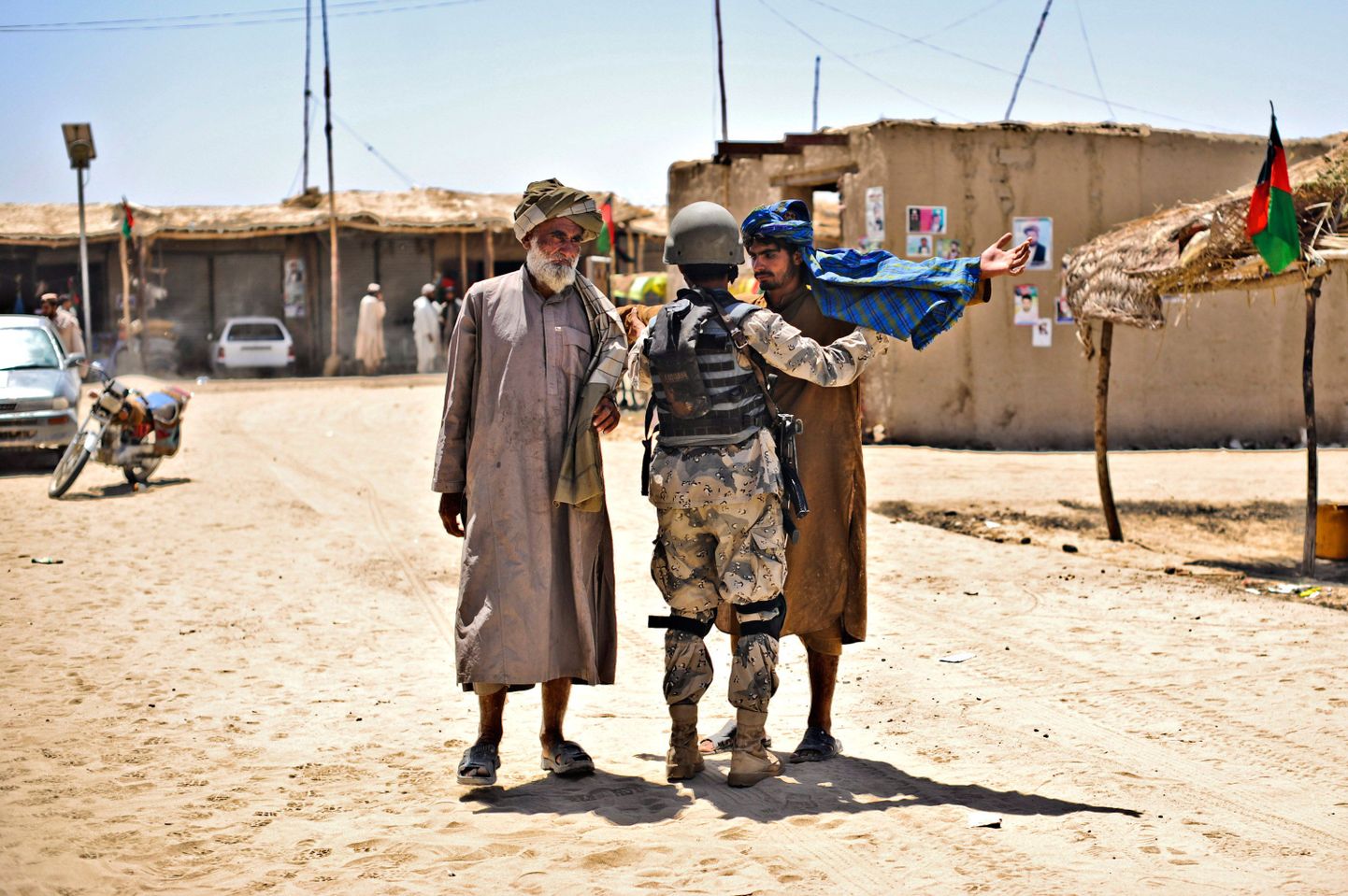 Sõdur kontrollib üle kaks valimisjaoskonda suunduvat afgaani Garmseris.
