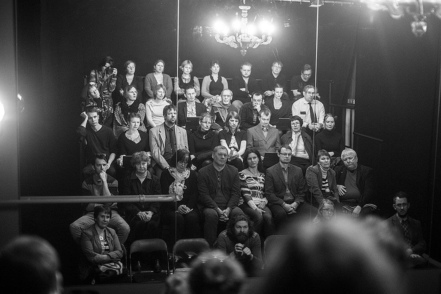 Tartu Uue Teatri väikese saali publiku hulgas peeglite ees mängib «Illusioonides» neli näitlejat: ülalt teises reas vasakult neljas on Mart Aas ja seitsmes Kristel Leesmend, ülalt kolmandas reas vasakult teine on Katrin Pärn ja vasakult kuues Siim Angerpikk.
