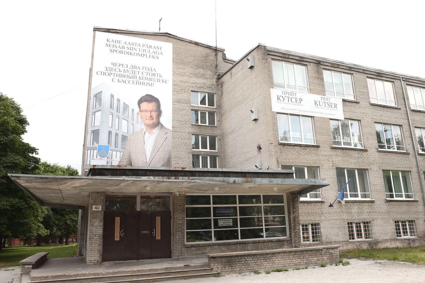 Keskerakondlase Priit Kutseri fotoga teavitus Põhja-Tallinnas Vene Eragümnaasiumi fassaadil.