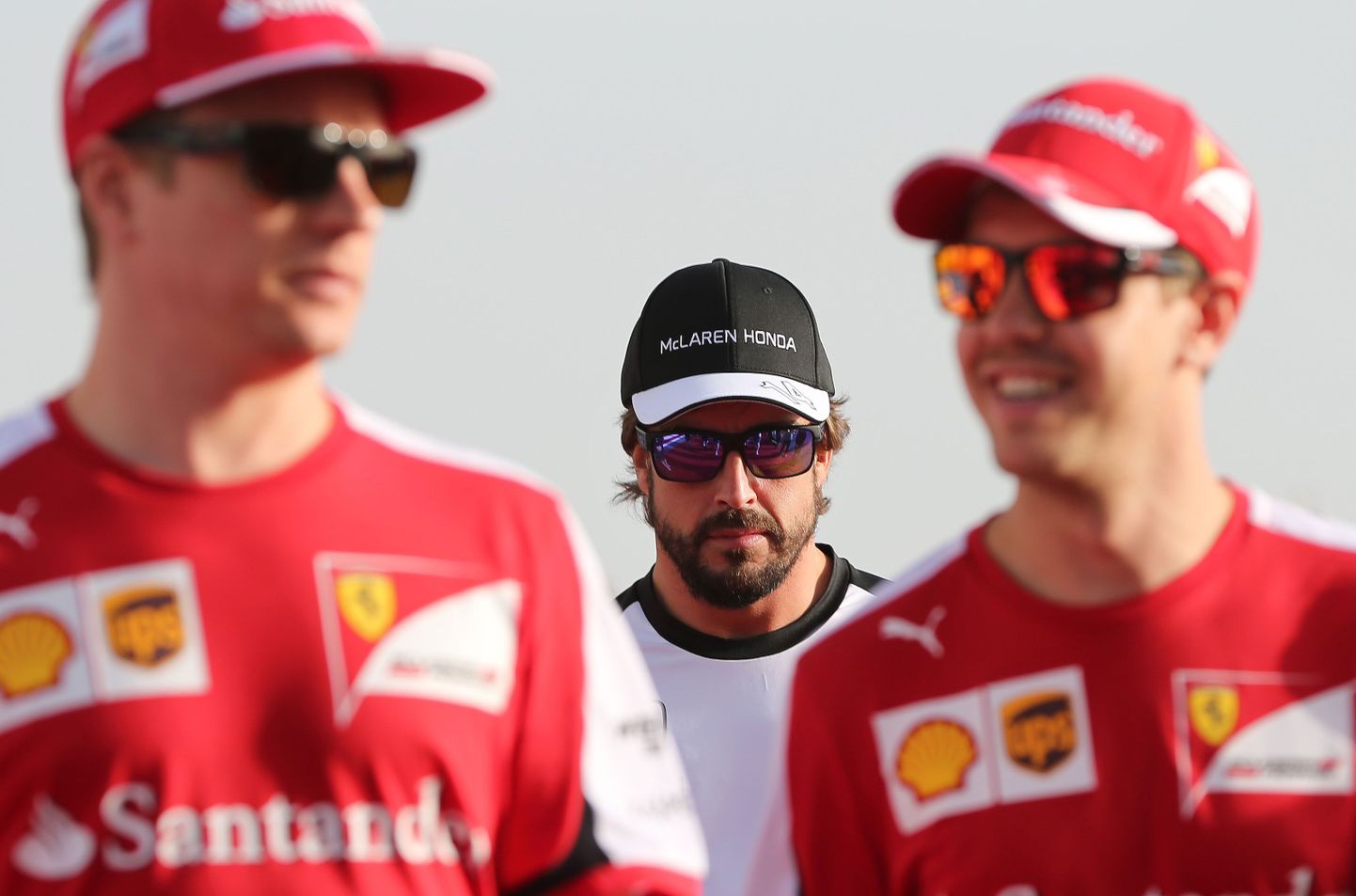 Taustal Fernando Alonso, esiplaanil Ferrari sõitjad Kimi Räikkönen ja Sebastian Vettel.