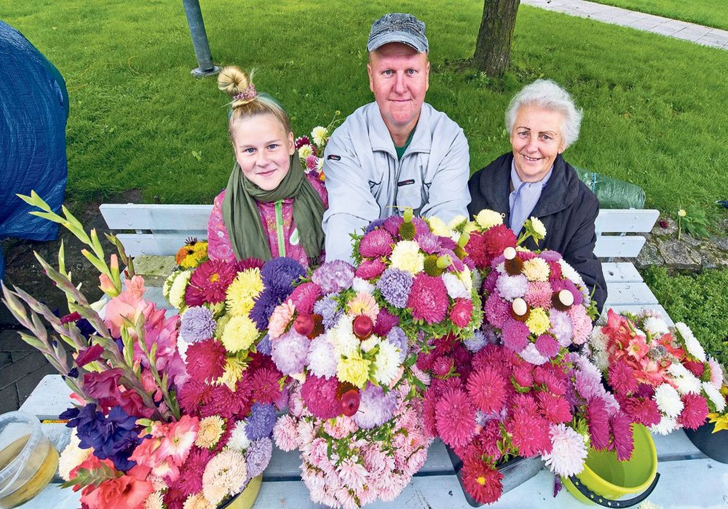 73-aastane Helju Menind (paremal) on 38 aastat kasvatanud koduaias lilli, et neid kevaditi ja sügiseti tartlastele müüa. Teisipäeval olid kaubamaja kõrval müügiletis abis ka tema poeg Illar ja lapselaps Mirtel.