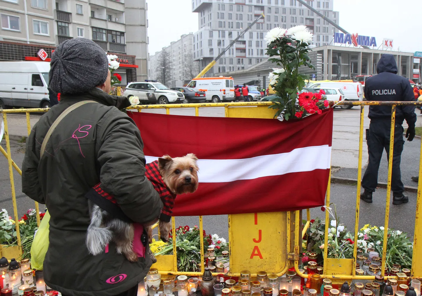 Lilled, küünlad ja Läti lipp Riia Maxima rusude juures.