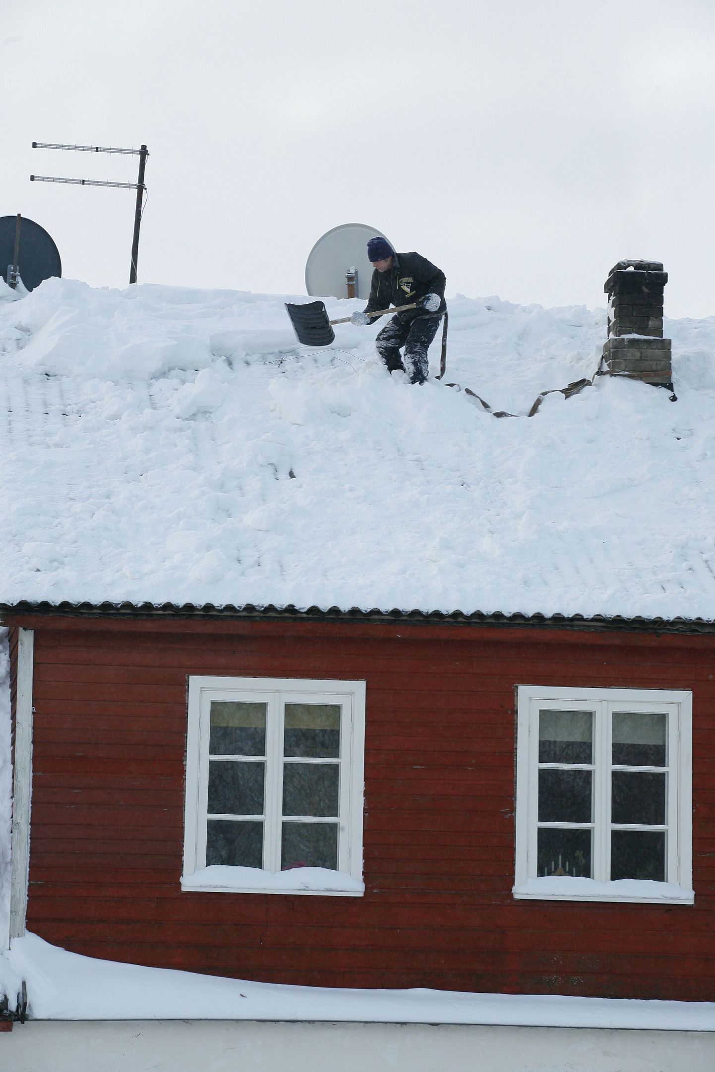 Во время уборки снега с крыши надо пристегиваться страховочным ремнем.