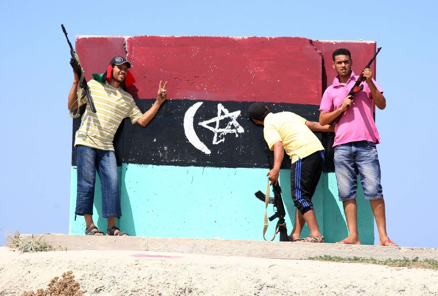 Liibüa mässulised poseerimas riigi vana lipu ees.