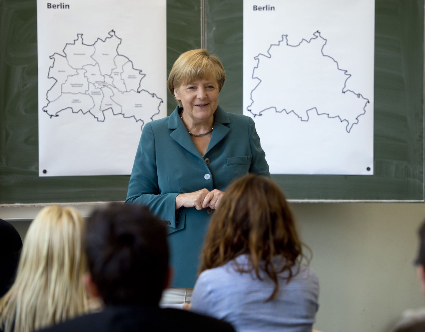 German Chancellor Angela Merkel  smiles as she lectures on the building of the Berlin Wall   Aug. 13, 1961 to a 12th grade class during her visit to the Heinrich Schliemann Gymnasium, secondary school in Berlin, Germany on  Tuesday Aug. 13, 2013.  (AP Photo/Odd Andersen,Pool) / SCANPIX Code: 436