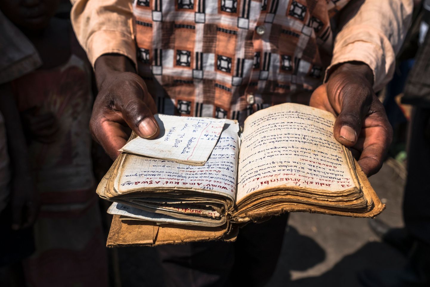 A Hutu priest shows his prayer book at the Internally Displaced Persons Camp (IDPs) in Buleusa on July 16, 2016. 
Tensions are high between Hutus and Kobos since the population started to return to the village after its evacuation by Rwandan Hutus Rebels (FDLR) in November 2015.     / AFP PHOTO / Eduardo Soteras