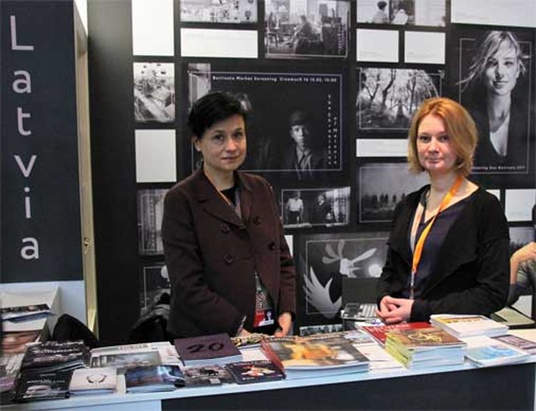 Mākslinieces Ilzes Začestas veidotajā stendā strādā Nacionālā Kino centra vadītāja Dita Rietuma un NKC pārstāve Zanda Dūdiņa 