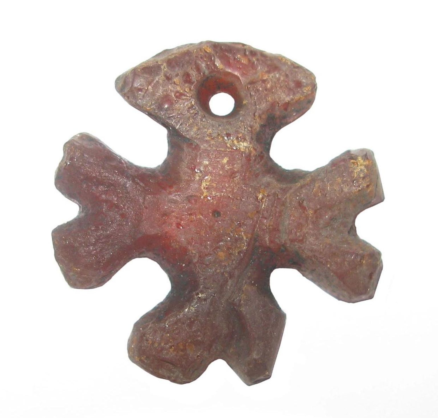 Ristikujuline merevaigust ripats (3 x 3 cm) Jurjevi asula kihist. Raamatus on see koos teiste arheoloogiliste leidudega lk 342. Hoiul Tartu linnamuuseumis.