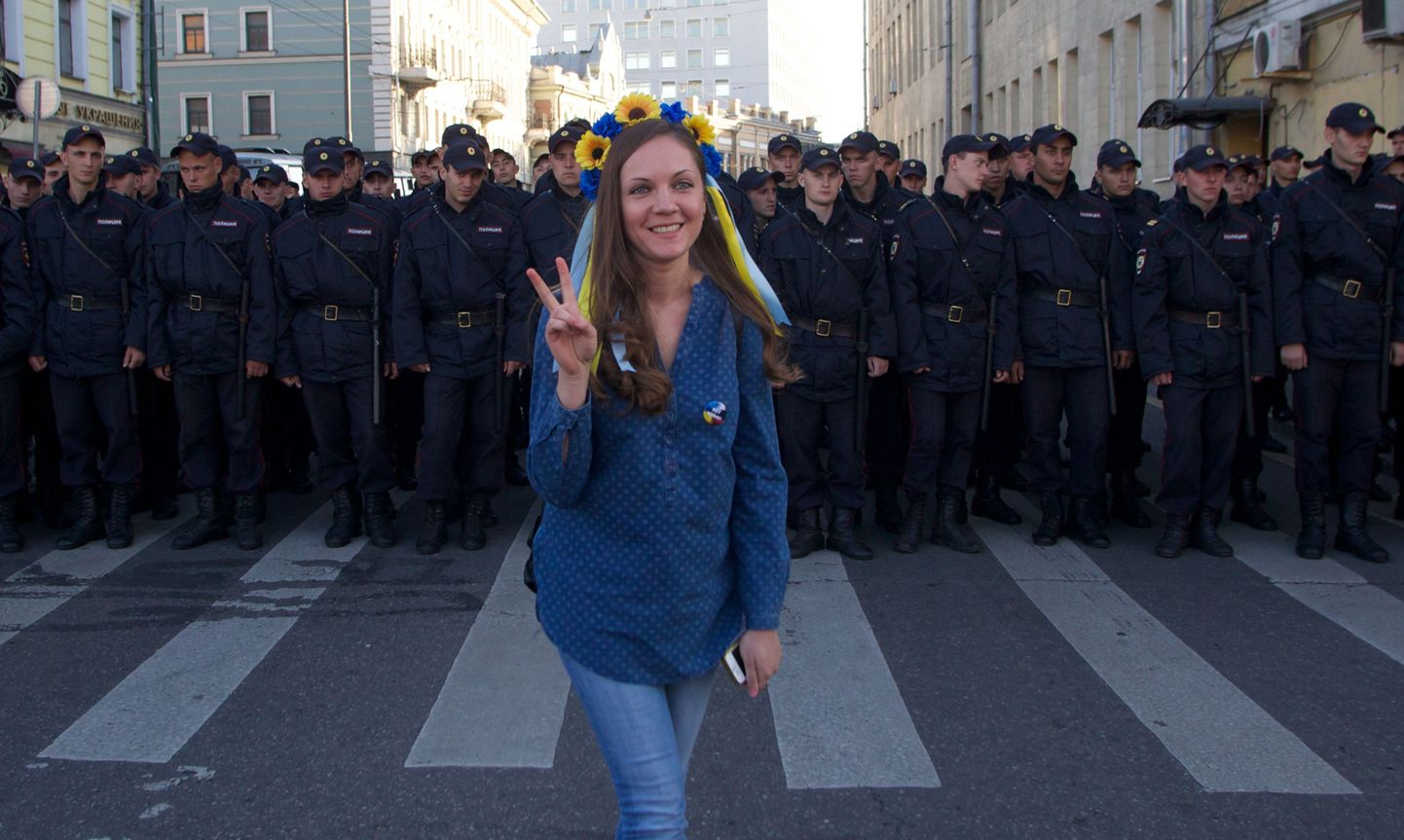 Ukraina lipuvärvides peakaunistust kandev noor naine möödunud kuul Moskvas Ukraina sõja vastasel meeleavaldusel politseirea ees.