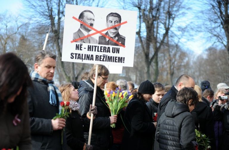 "Нет режимам Гитлера и Сталина!" - надпись на плакате людей, возлагающих цветы к памятнику Свободы в память о легионерах, 16 марта 2014 года