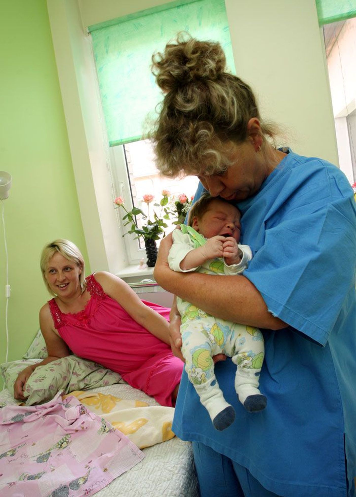 Акушерка Раплаской больницы Aйлен Вибус (с ребенком на руках) считает, что у маленьких больниц есть свои плюсы. Рядом на фото счастливая мама Яаника Калдма.