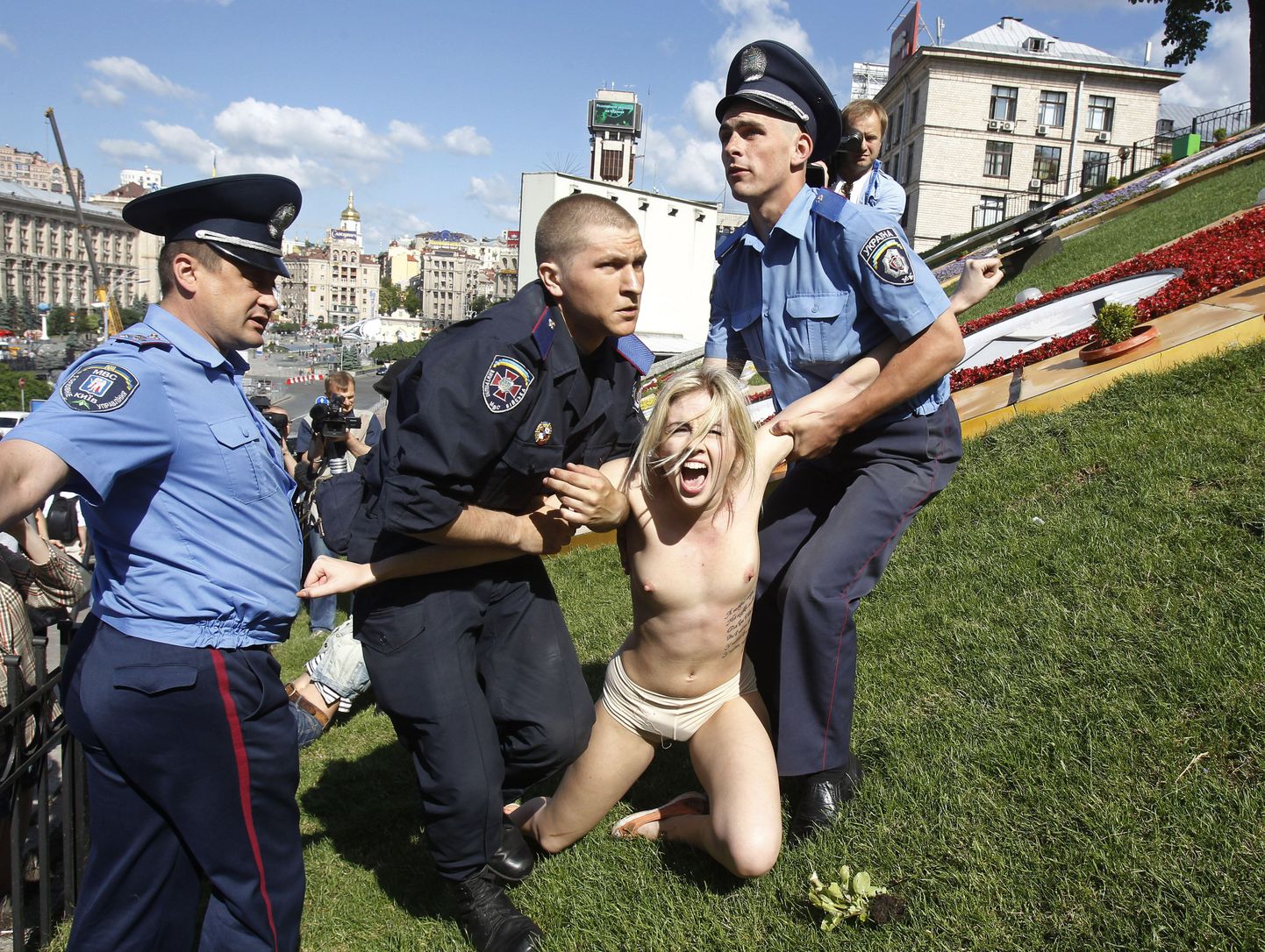 Украинские милиционеры задерживают одну из участниц движения Femen.