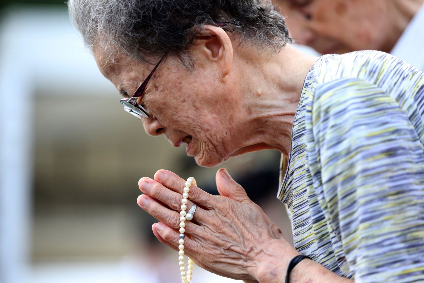 Женщина плачет в Парке мира в Нагасаки.
