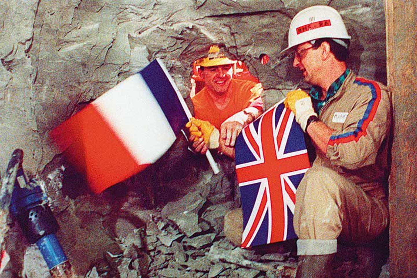 1. detsembril 1990 vahetasid inglise kaevur Robert Fagg (vasakul) ja prantsuse ametivend Philippe Cozet 22,3 km kaugusel Inglismaa ning 15,6 km kaugusel Prantsusmaa rannikust riigilippe, tähistades nõnda tunneli läbimurde saavutamist.