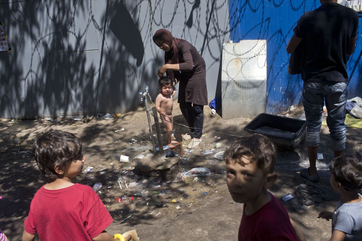 Naine Ungari-Serbia piiril asuvas põgenikelaagris oma last pesemas.