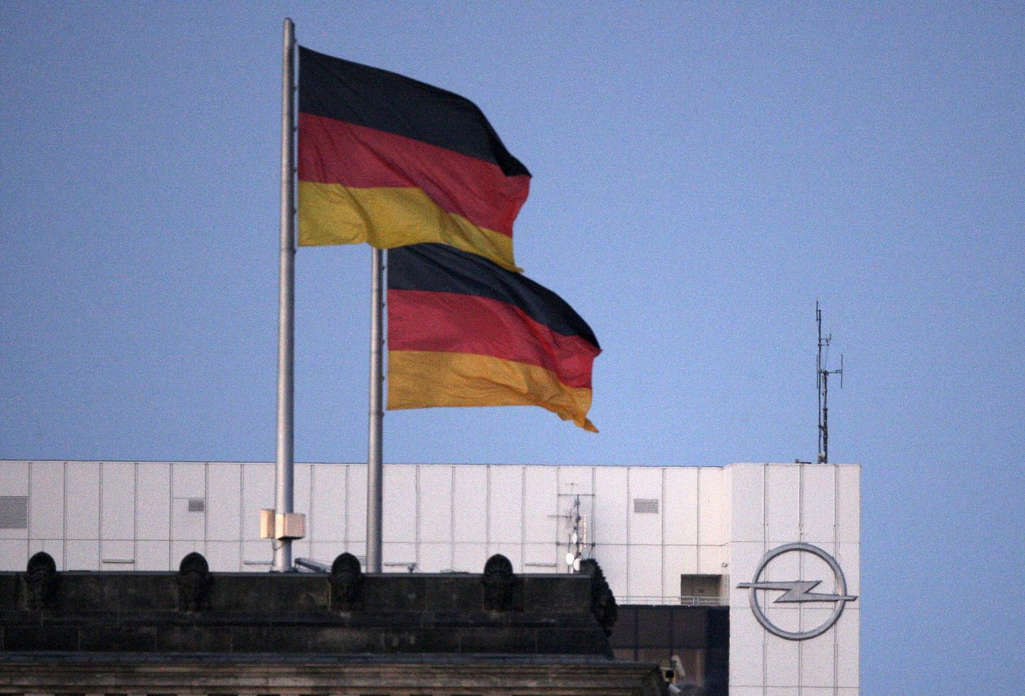 Saksamaa lipud Opeli logoga maja ees.