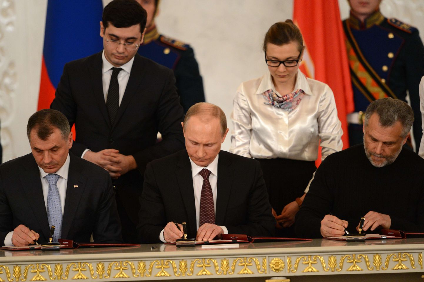 Venemaa president Vladimir Putin, Krimmi parlamendispiiker Konstantionov ning Sevastoopoli uus linnapea Aleksei Tšalõi kirjutavad alla Krimmi Venemaaga liitmise lepingule.