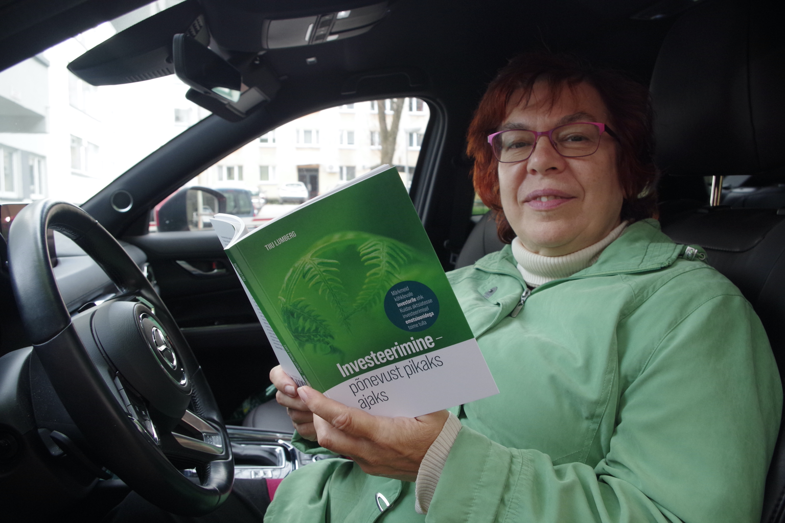 Tiiu Lumberg hoiab käes äsja trükist tulnud raamatut