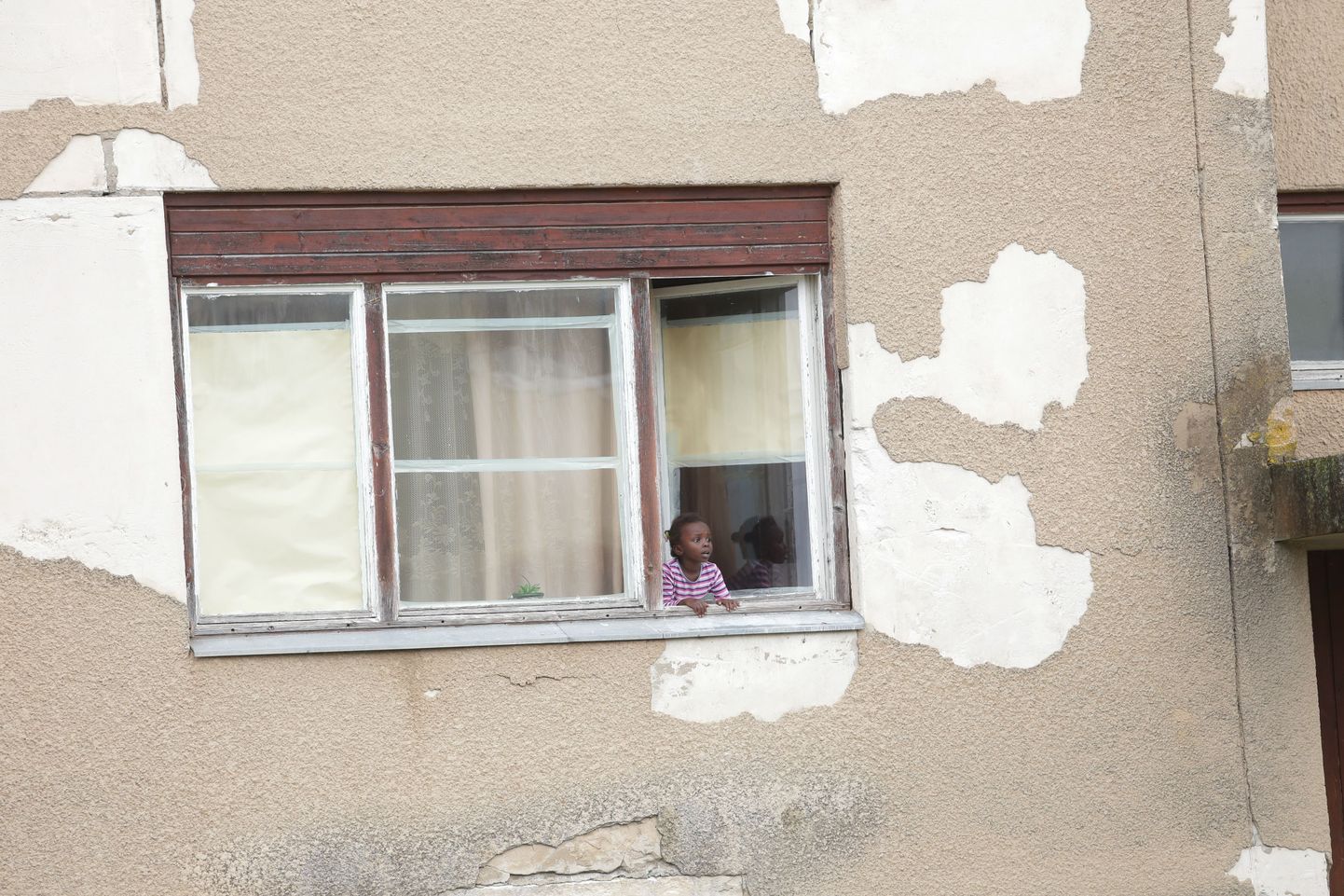 Väike tüdruk Vao pagulaskeskuse hoone aknal