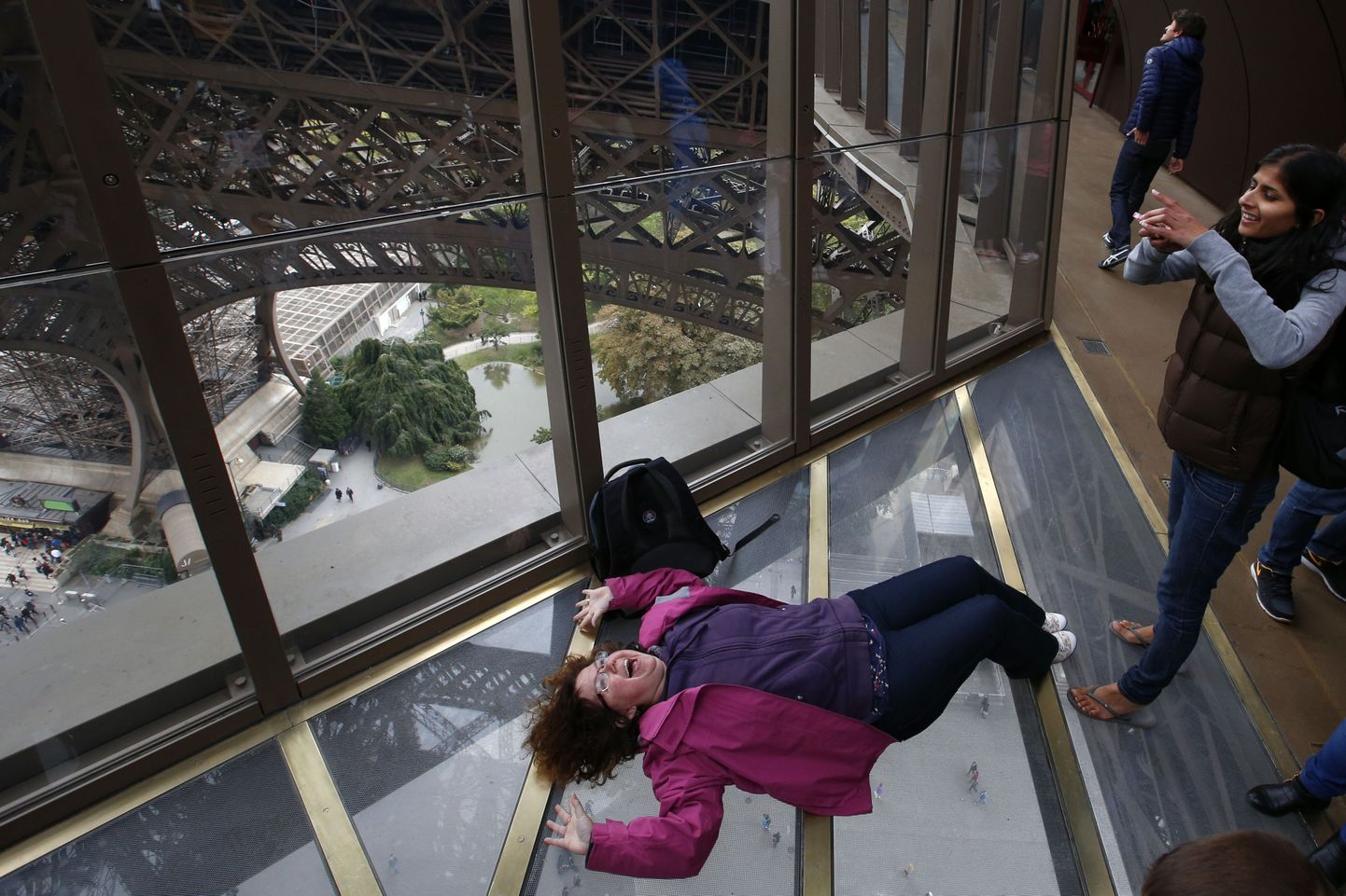 Külastaja tegemas pilti Eiffeli torni esimesel korrusel, kuhu paigaldati vaatamisväärsuse 125. sünnipäeva puhul klaaspõrand.
