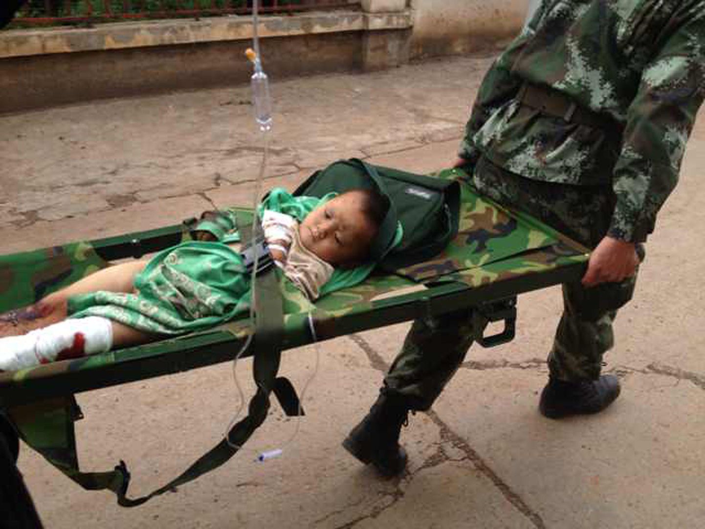 Päästjad abistamas maavärinas vigastada saanud last Zhaotonis.
