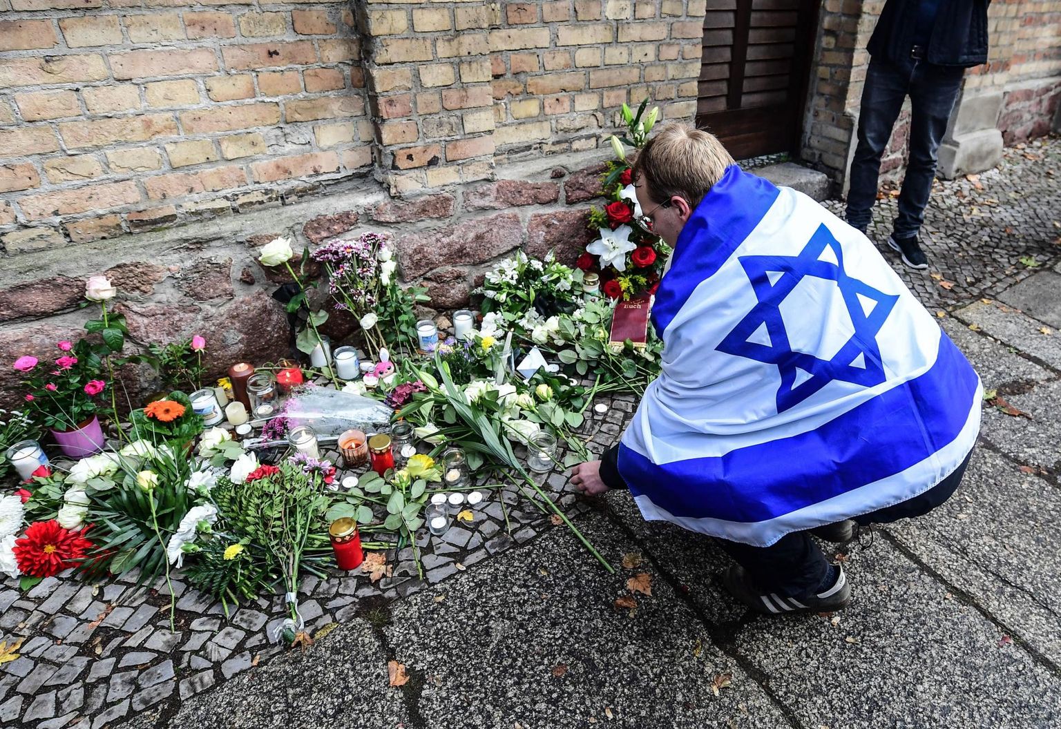 Juudivastased rünnakud Euroopas on viimastel aastatel sagenenud ja uuringute järgi tajub seda ligi 90 protsenti Euroopas elavatest juutidest. Pildil mälestab Iisraeli lipuga mees 2019. aasta oktoobris Saksamaal Halles rünnakus sünangoogile hukkunuid.