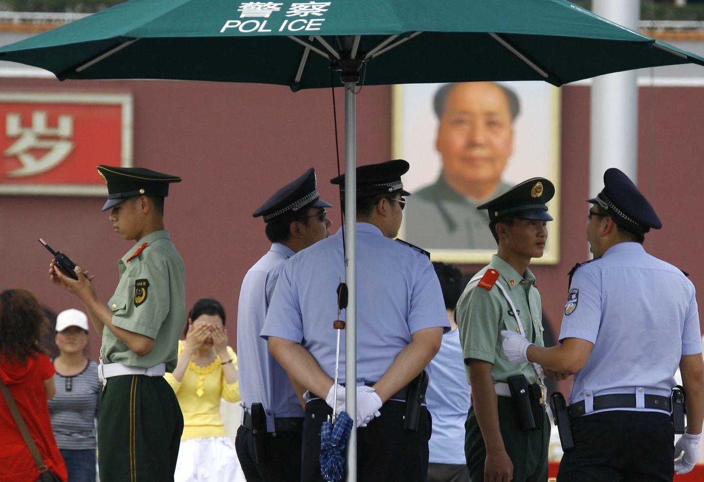 Hiina politseinikud täna Tiananmeni väljakul Mao Zedongi portree ees.
