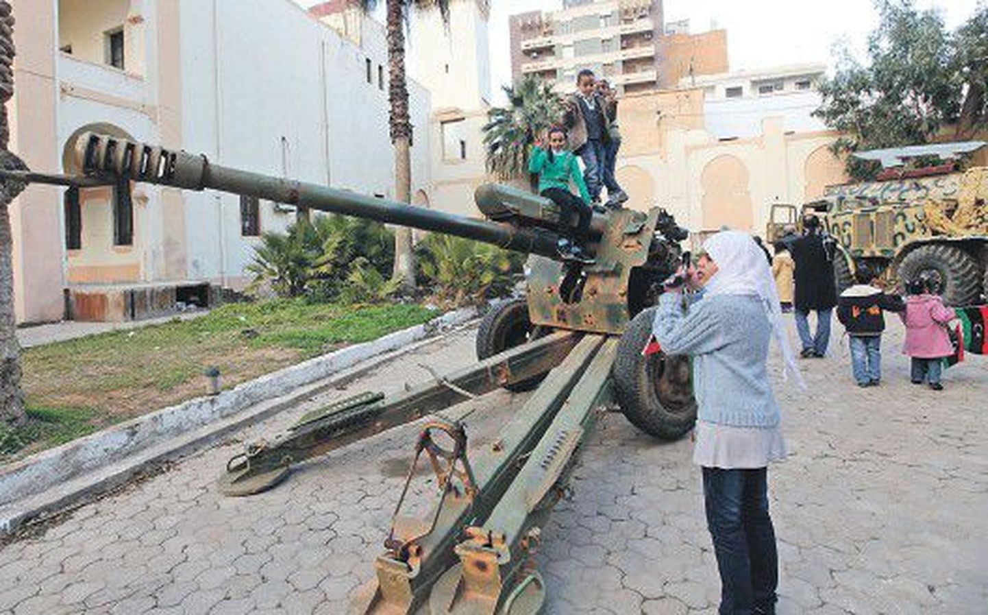 Пока правительство пытается вернуть жизнь в мирное русло, дети Ливии изучают пушку, выставленную на всеобщее обозрение по случаю первой годовщины ливийской революции.