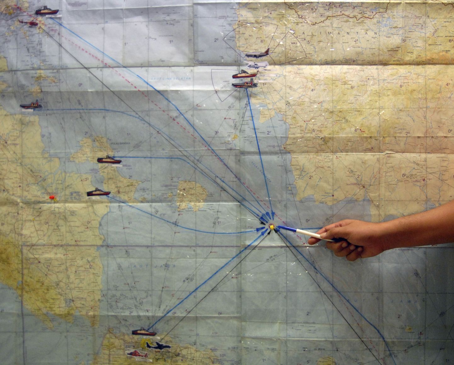 Indoneesia lennuki otsimise operatsiooni koordineerimiskeskuse töötaja näitamas kaardil ala, kust lennukit otsitakse