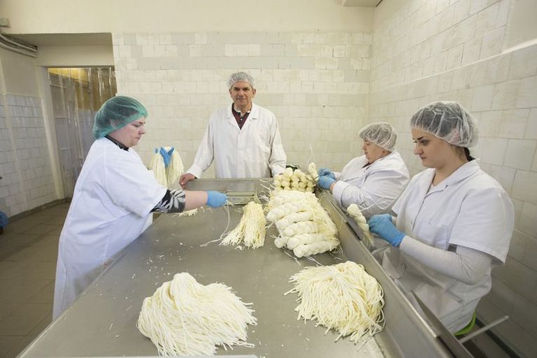 Ettevõtte juht Arut Arutjunjan (keskel) juustutsehhis, kus niidid punutakse patsideks.