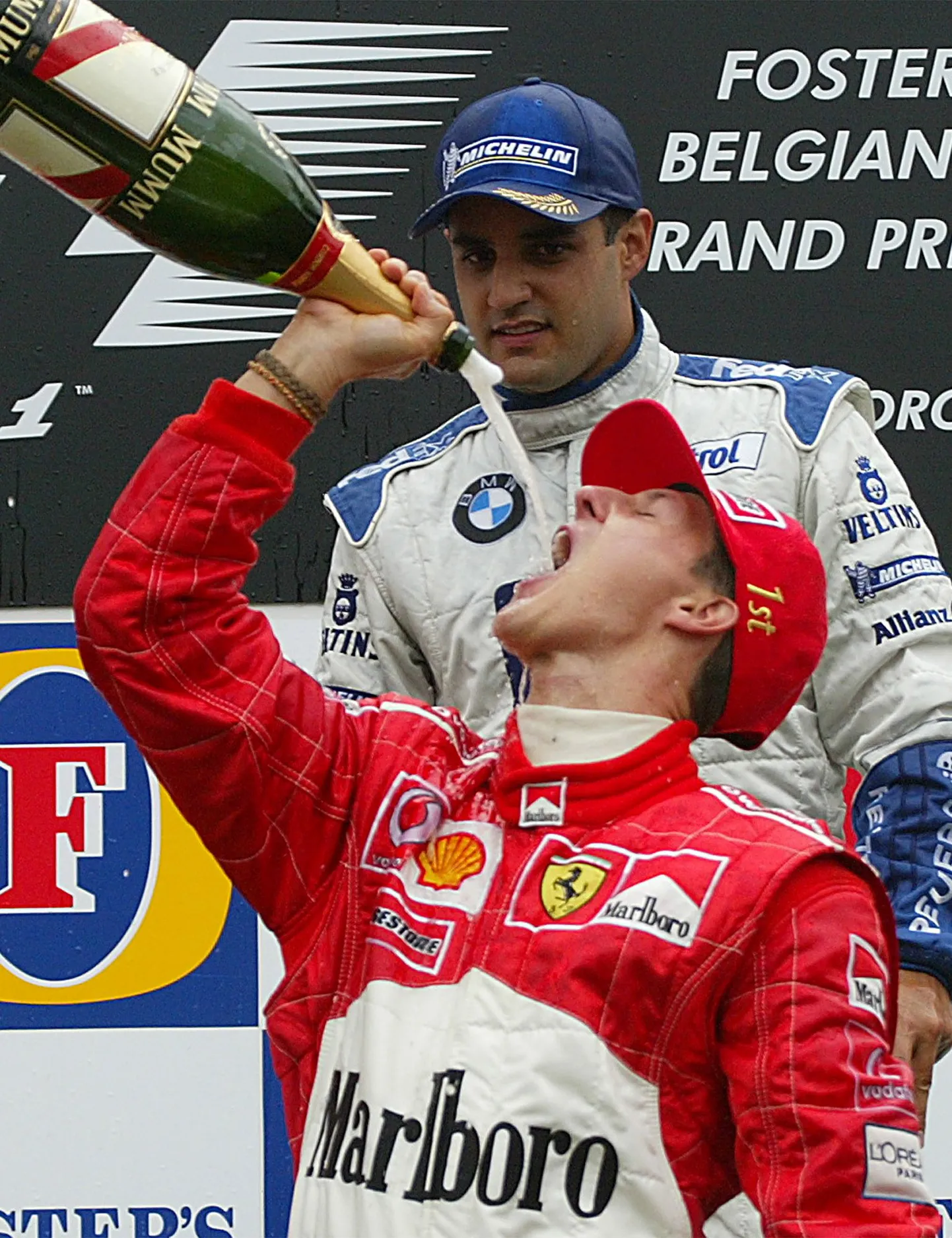 Juan Pablo Montoya vaatab kadedusega kuidas maailmameister Michael Schumacher šampanjat kulistab.