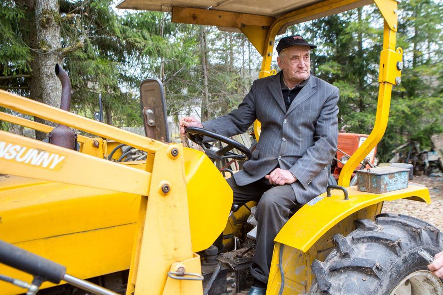 85-aastane Anton Reinart käib oma traktoriga abiks ka külarahval.