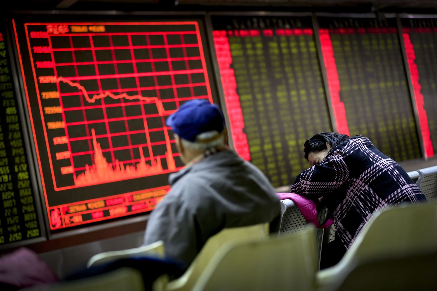 Kaks aktsiakauplejat eile Pekingis börsimaaklerifirmas hindu kuvava ekraani ees. Eakas mees (vasakul) silmitses üha langevaid hindu, keskealine naine kasutas aga võimalust teha väike uinak.