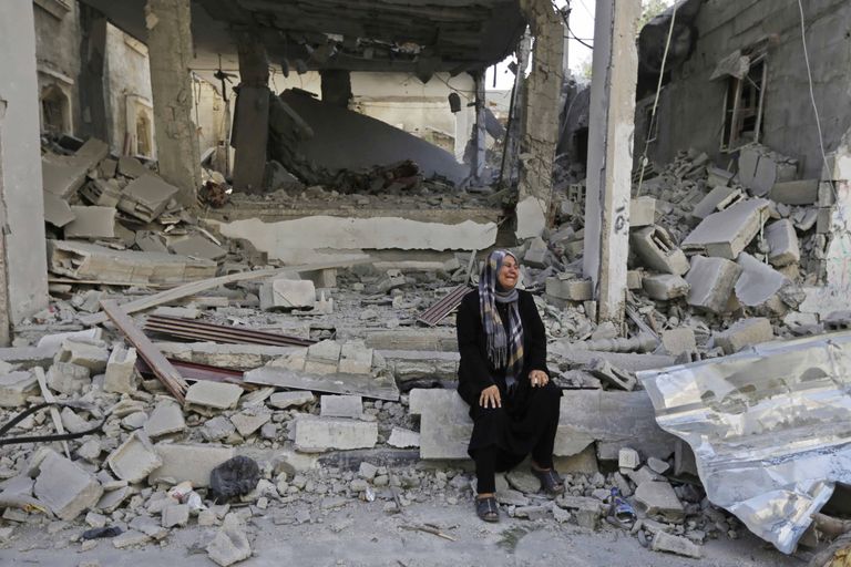 Palestiinlanna oma purustatud kodu varemetel.