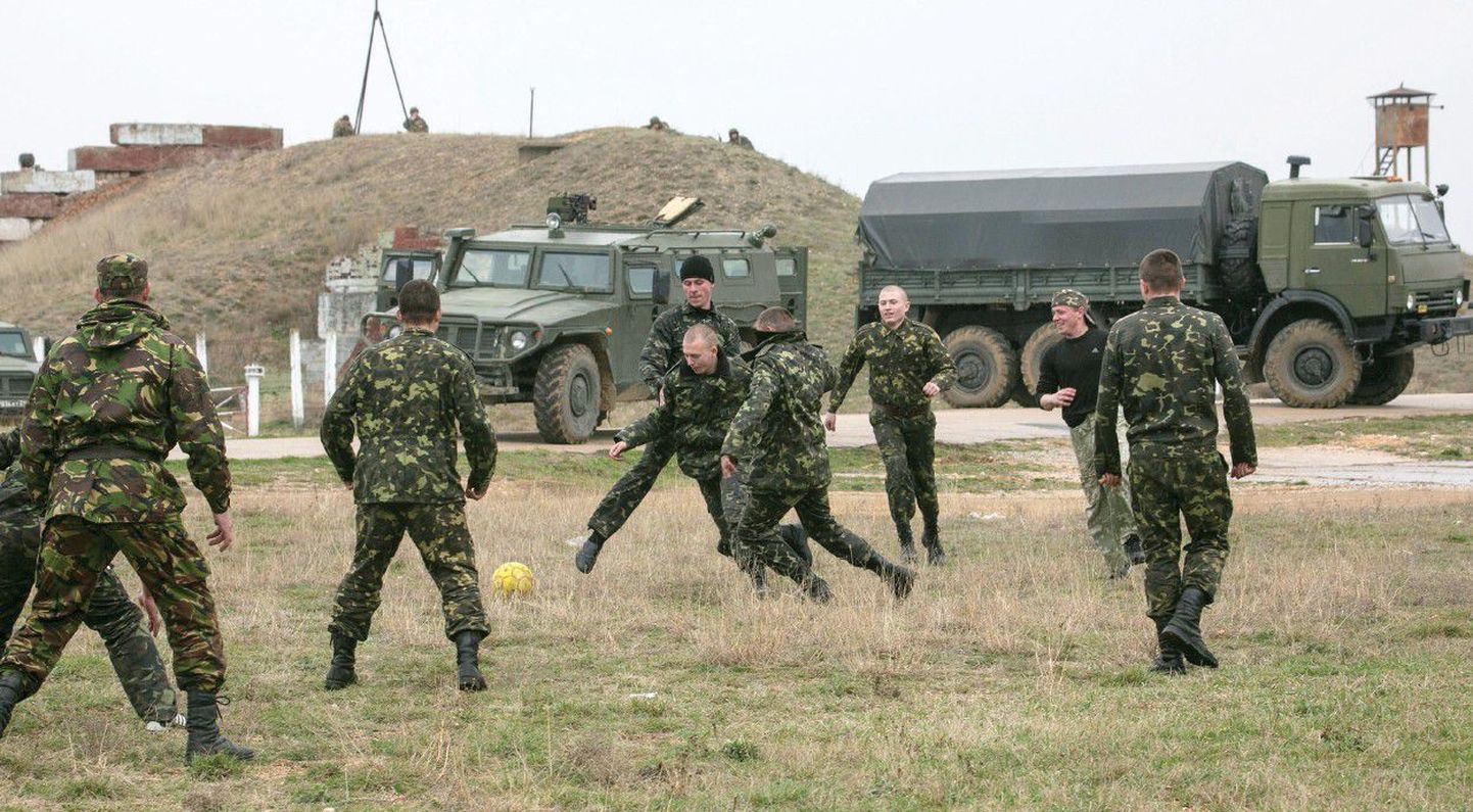 Мир или война? Украинские солдаты играют в футбол рядом с российскими военными машинами возле крымского аэропорта «Бельбек».