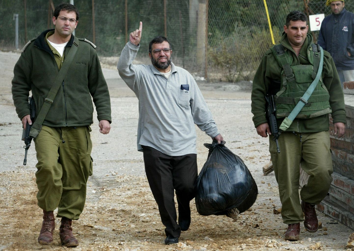 Hamasi kõneisik ja okupeeritud läänekalda alade liider Sheik Hassan Yousef kõndimas Iisraeli sõdurite saatel sõjaväevanglast välja.