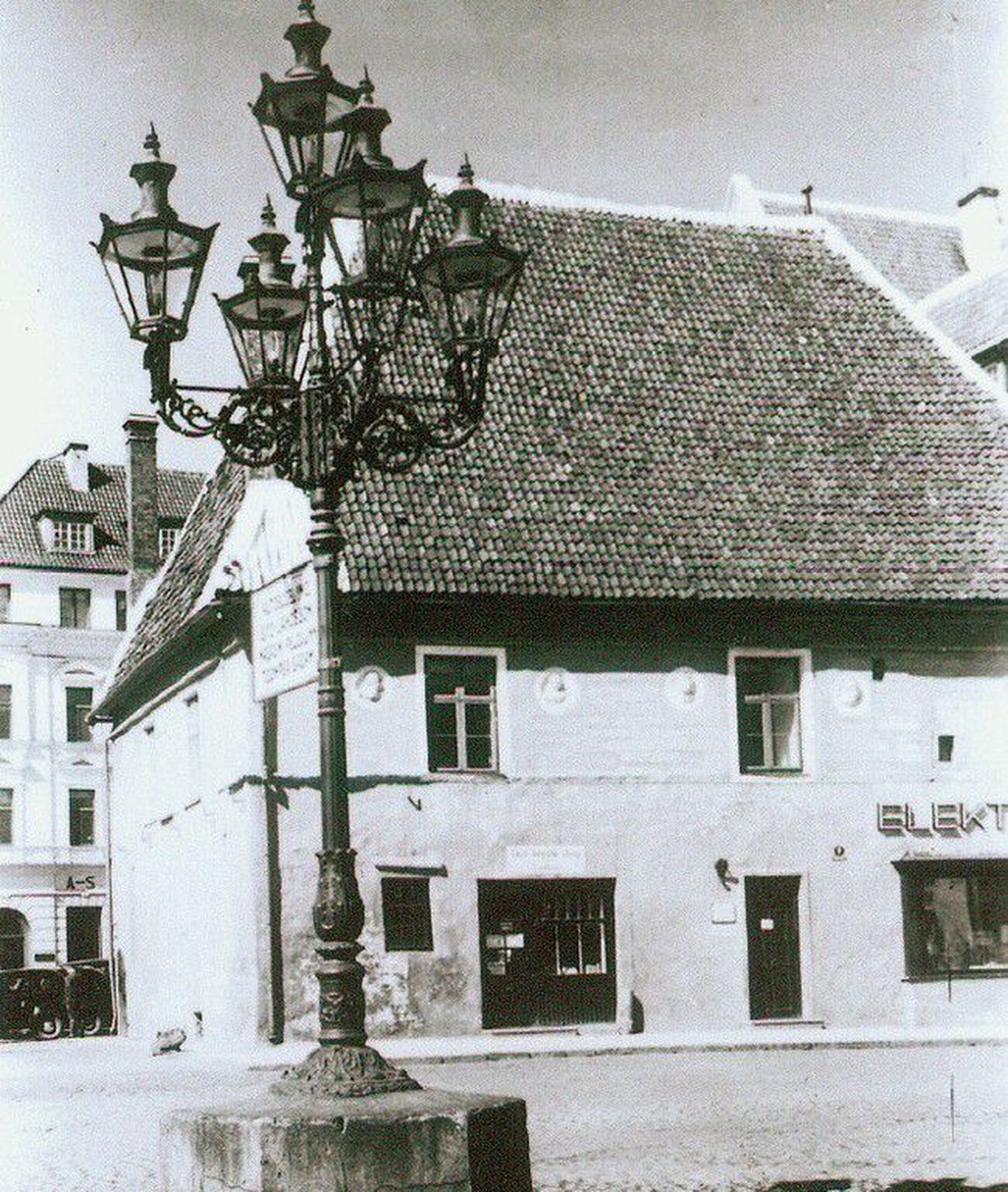 Tänavavalgustuslatern 1930. aastatel Raekoja platsil. Taustal paistab 1944. aasta märtsipommitamises hävinud vaekoja hoone.