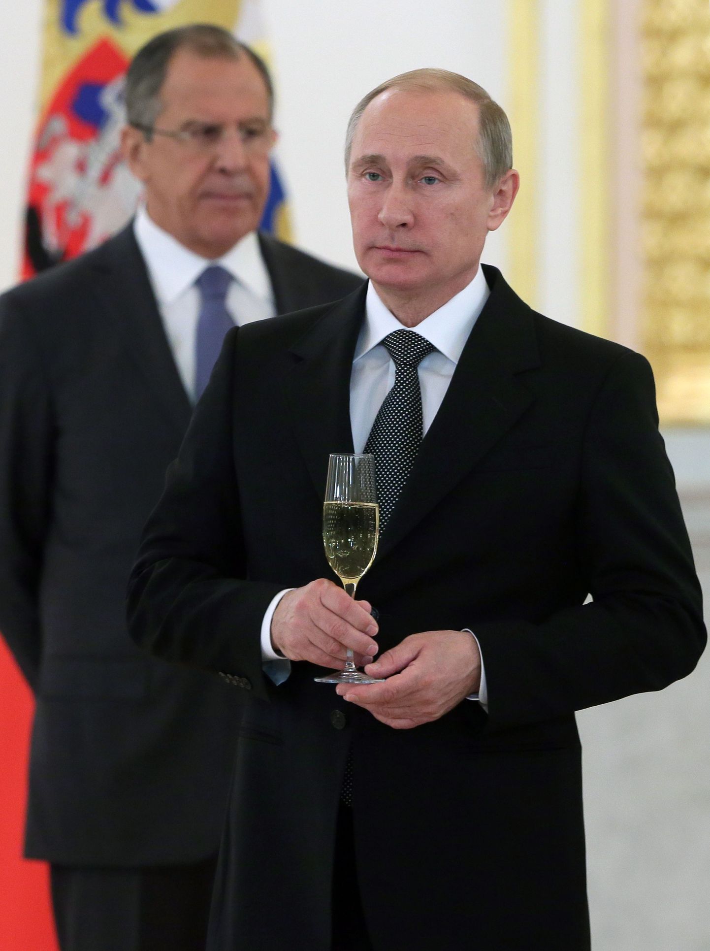 Vene president Vladimir Putin hoiab käes šampanjaklaasi, kohtudes Kremlis välisdiplomaatidega. Taga paistab välisminister Sergei Lavrov.