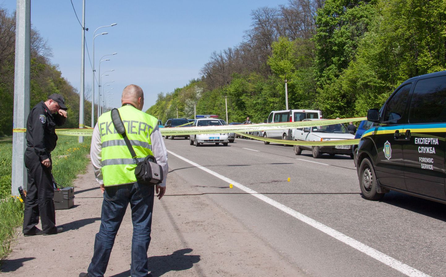 Ukraina miilitsatöötajad Harkivis Belgorodi maanteel, kus tundmatu kurjategija tulistas jalgrattaga sõitnud linnapead Gennadi Kernest.