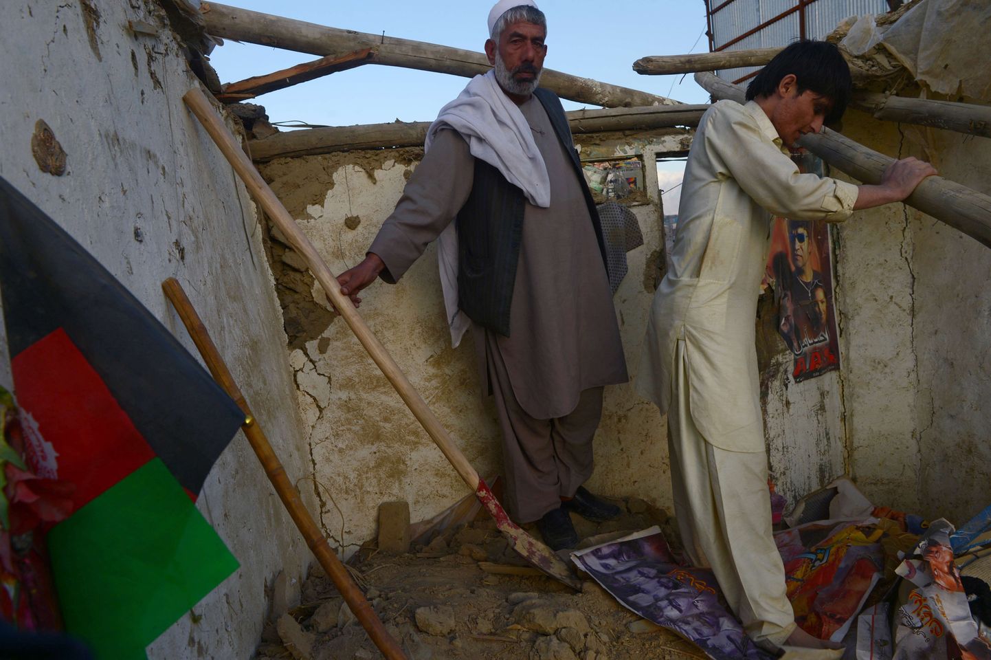 Жители Афганистана осматривают повреждения, нанесенные жилому дому в результате землетрясения.