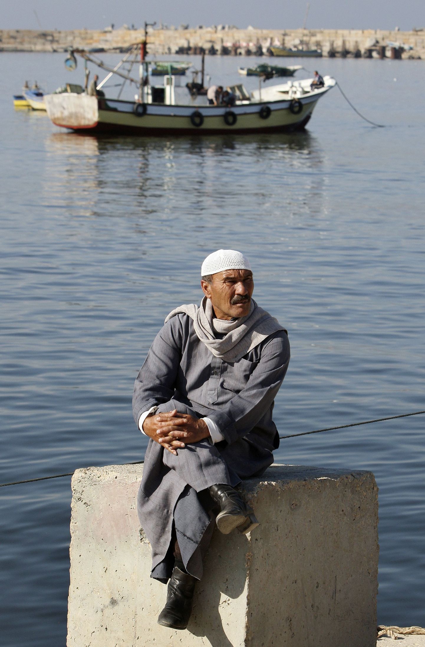A Palestinian man waits for a Libyan ship at the seaport in Gaza December 1, 2008. The Israeli navy turned back a Libyan ship on Monday as it tried to transport humanitarian aid to the blockaded Gaza Strip, Palestinian officials said. They said the ship, Al-Marwa, sailed to a port in neighbouring Egypt instead. REUTERS/Suhaib Salem (GAZA)
